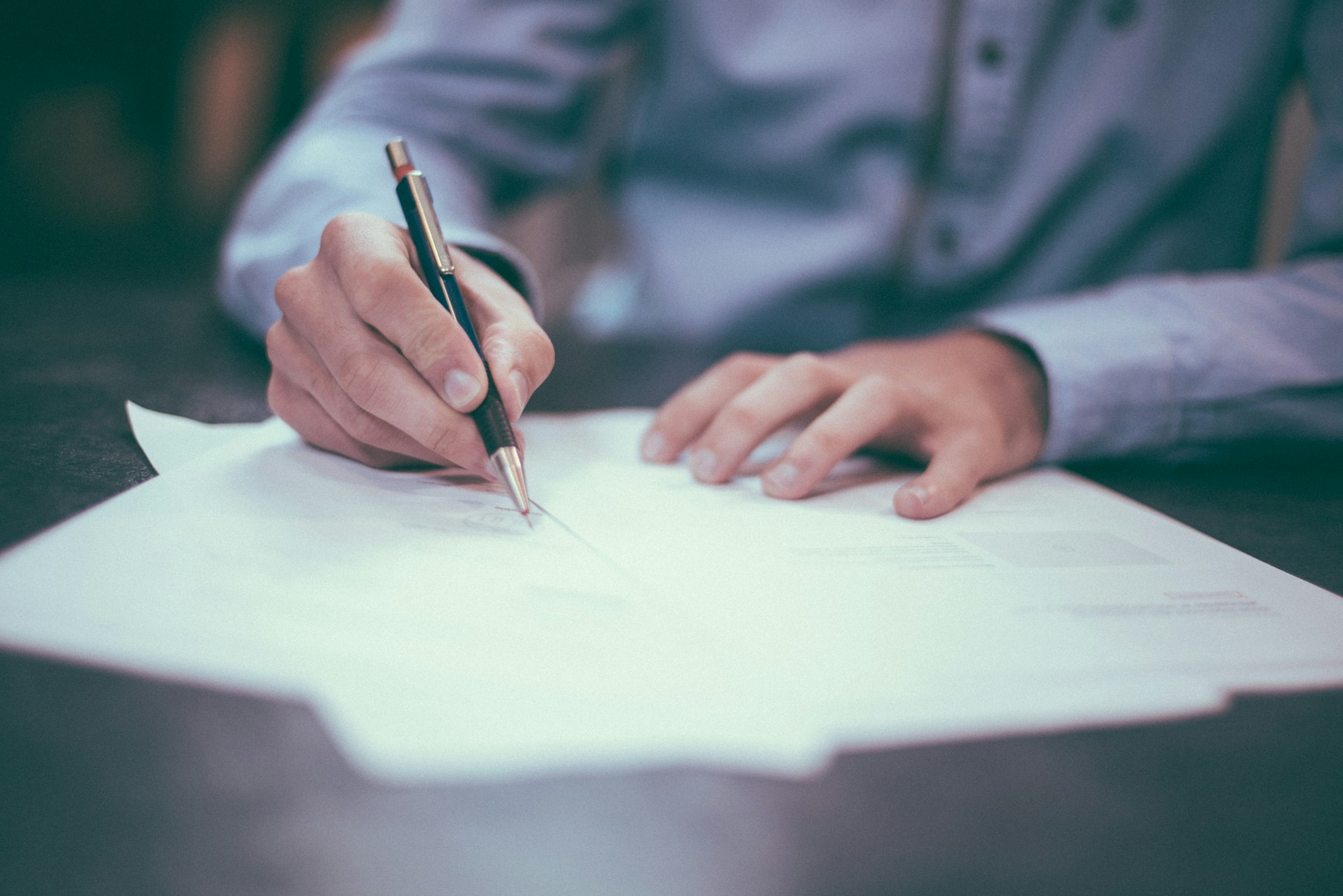 Insurance broker at a desk reviewing policy documents with a client in an Indian advisory office